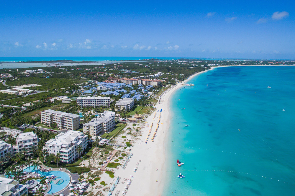 A bird's-eye view of a resort town and beach on one of the Turks & Caicos islands
