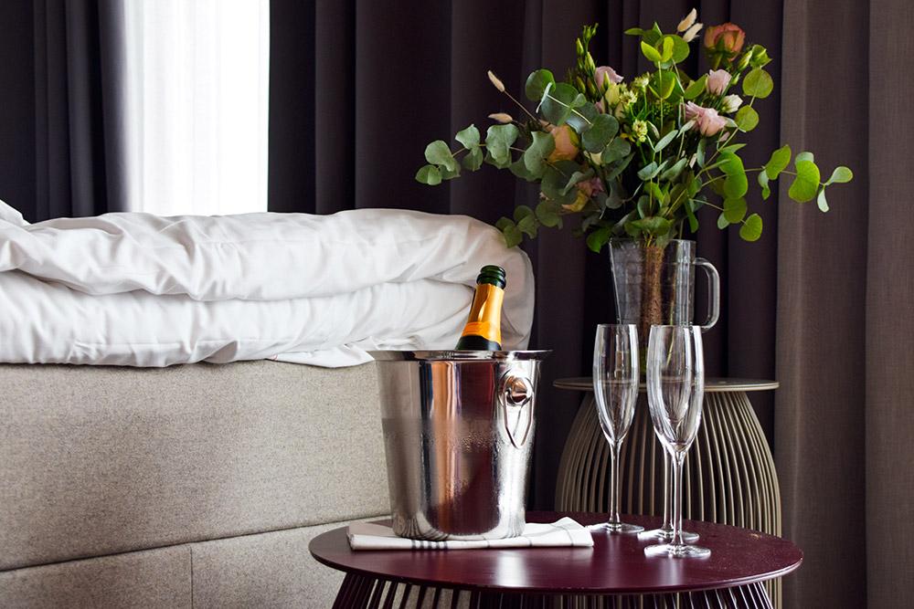 Bottle of champagne in a bucket of ice with two champagne glasses in a hotel room