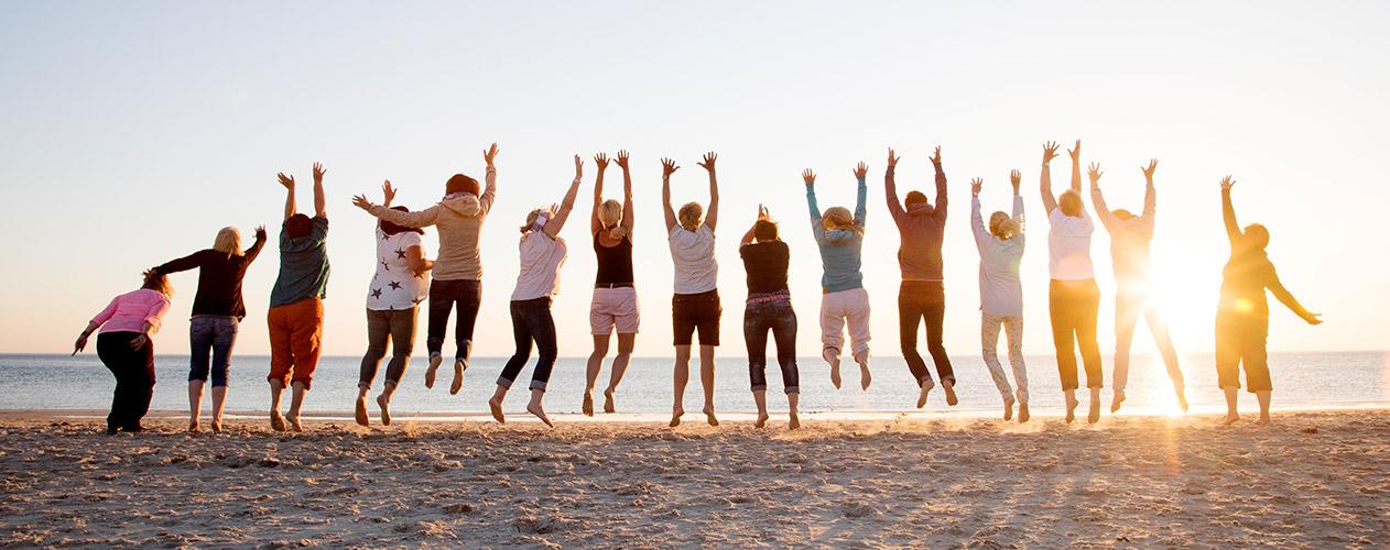 A group of travelers jumps on a beach