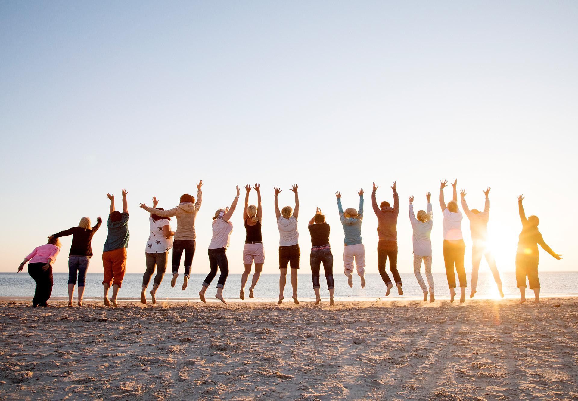 A group of travelers jumps on a beach