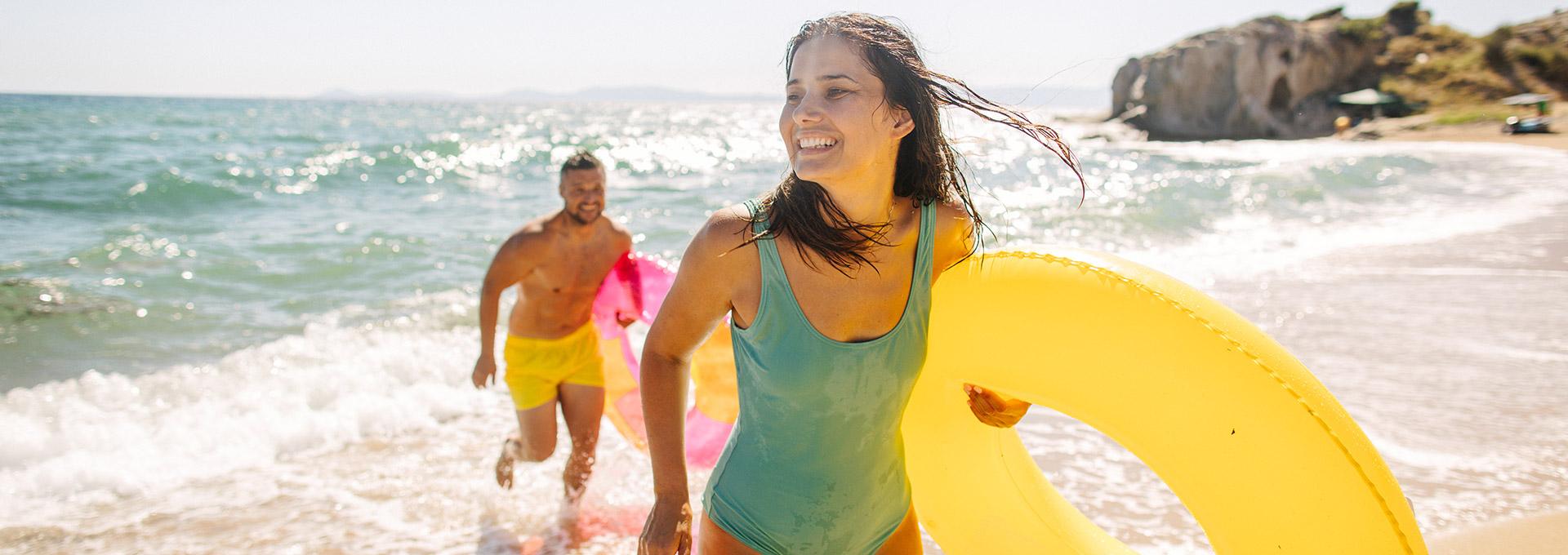 A couple with floating tubes on the beach