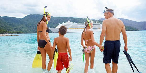 A family with a cruise ship in the background