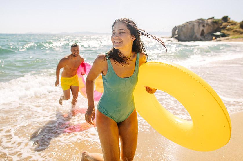 A couple with floating tubes on the beach