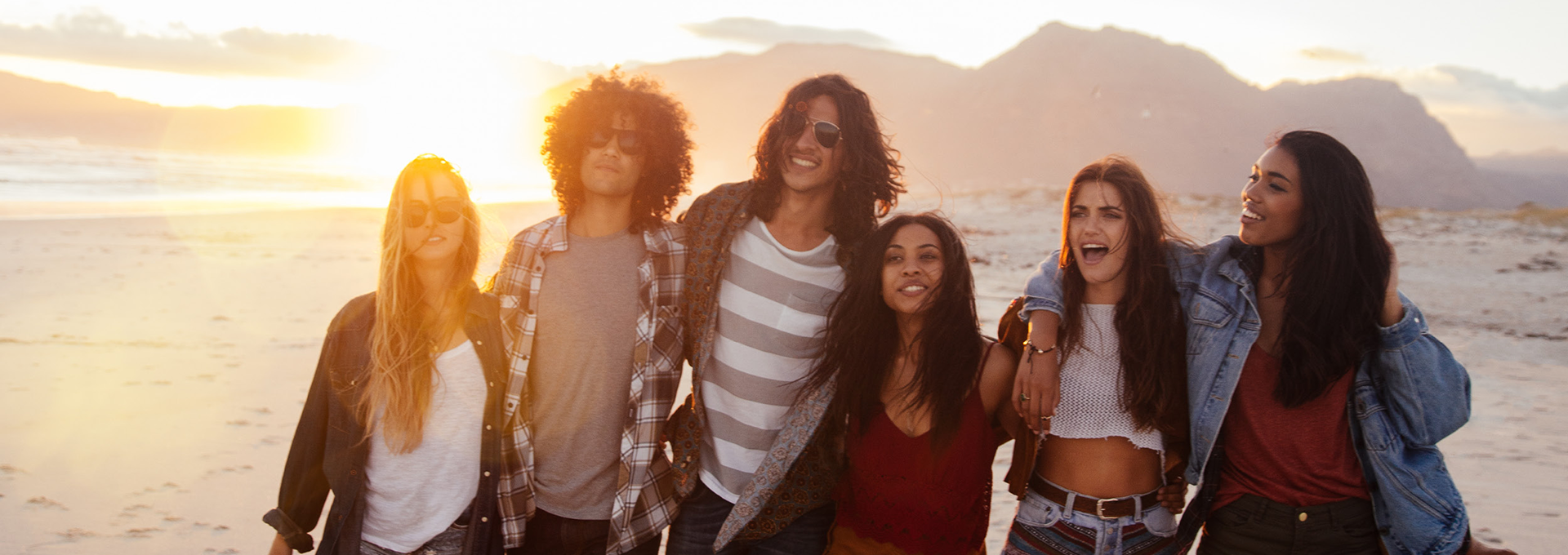 A group of friends walk along the beach