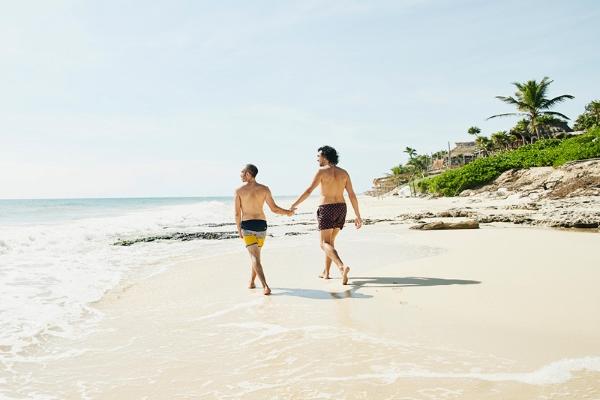 Wedding couple holding hands while walking on the beach