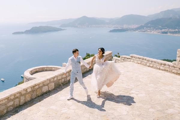 Bride and groom on an observation deck overlooking the island of Sveti Stefan