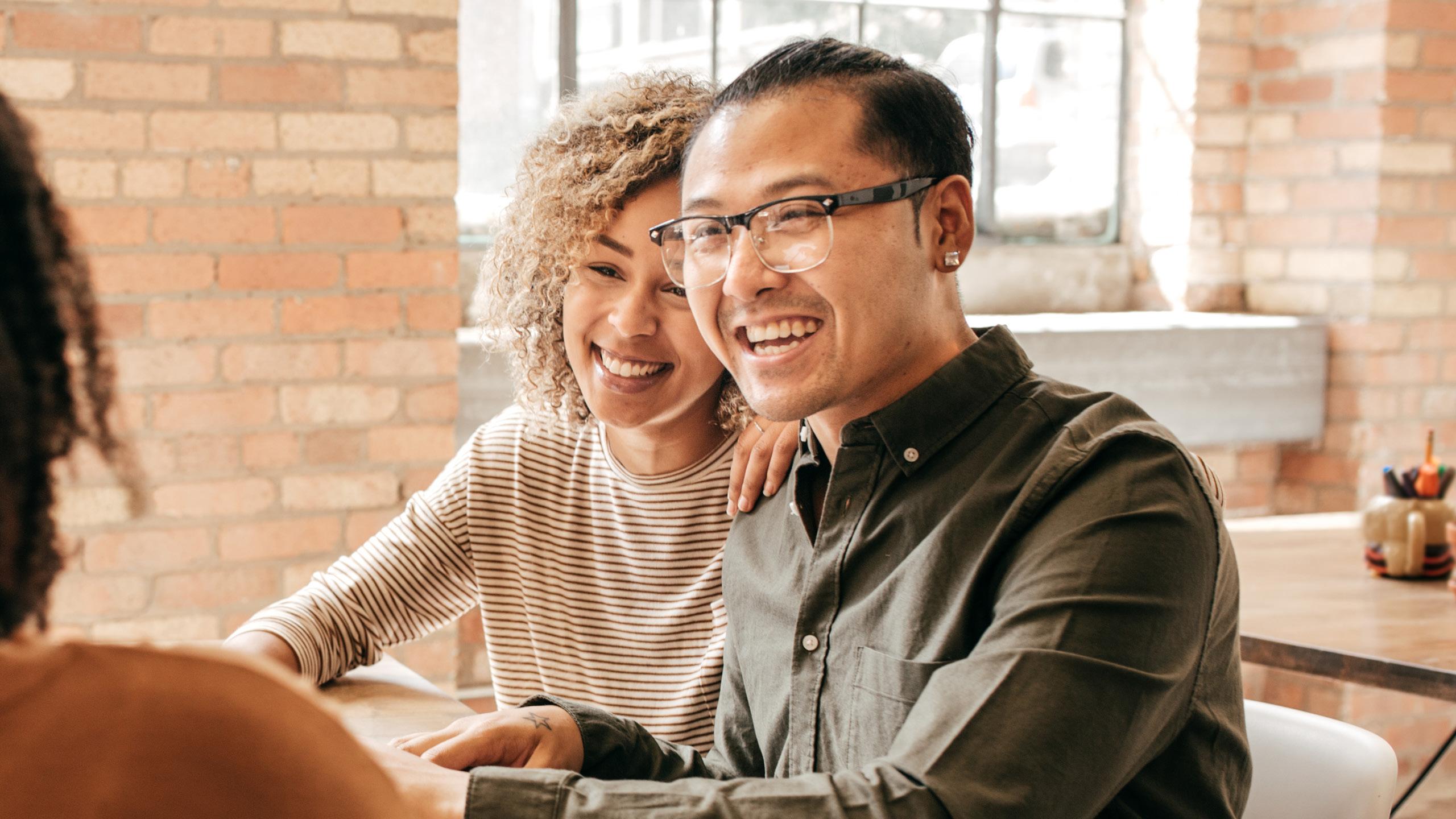 Couple looking happy while speaking to travel advisor about destination weddings