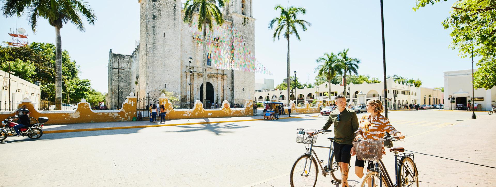 Couple walking their bikes while touring a foreign city