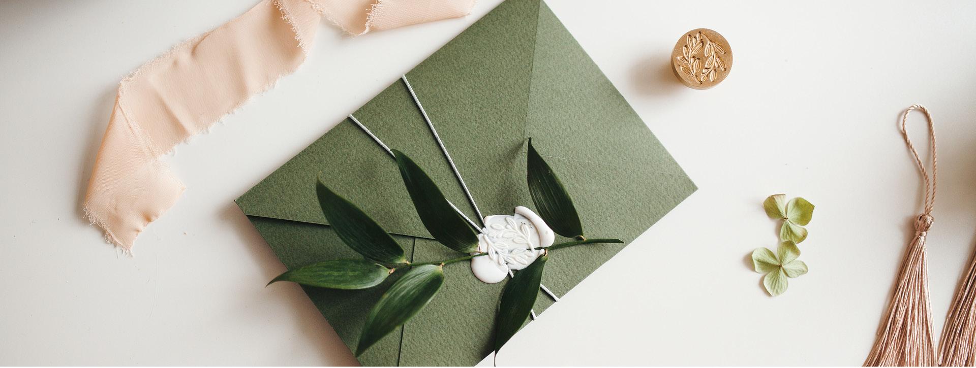 Wedding invitation in green envelope with a wax seal