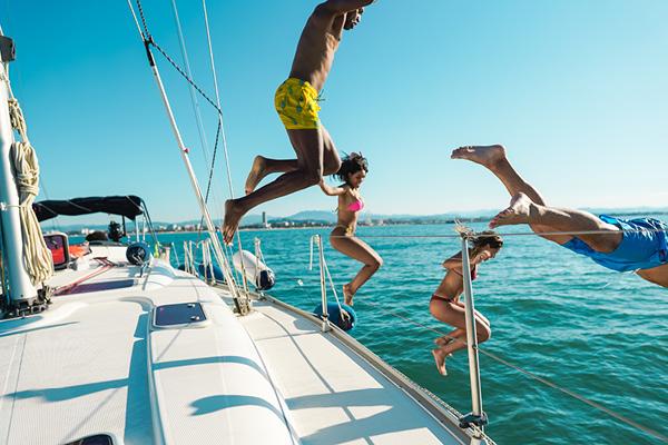 Group of people jumping off catamaran
