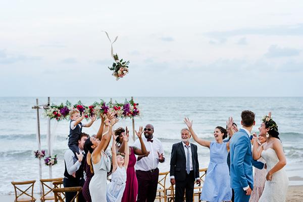 Destination wedding guests attempting to catch bridal bouquet