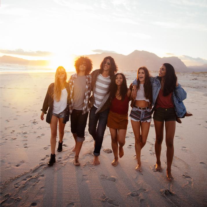 A group of friends walk along the beach