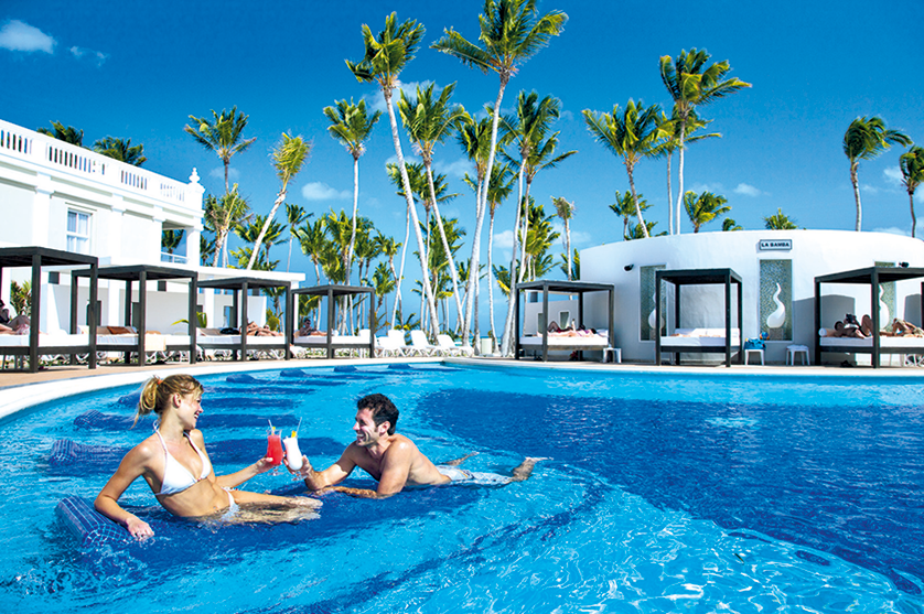 A couple enjoys drinks in the pool at a Riu resort