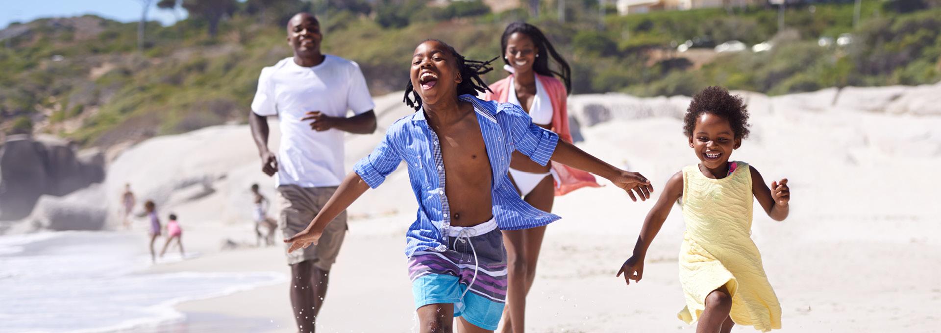 A family runs on the beach while on vacation